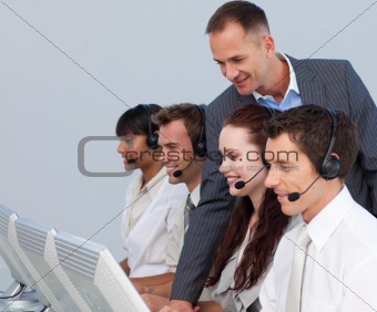 Attractive manager checking his team work in a call center