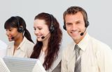 Smiling young businessman working in a call center