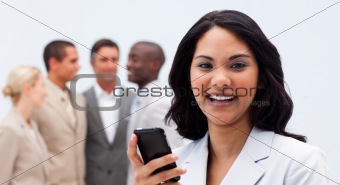 Smiling ethnic businesswoman texting with a mobile phone