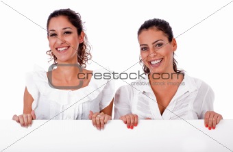 Happy young business colleagues holding a white blank board
