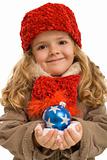 Little girl in warm clothes holding blue christmas ball