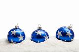 Three blue christmas balls in the snow - isolated