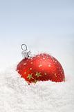 Red christmas bauble in the snow
