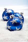 Three blue christmas balls in snow