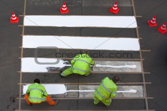 workers painting crosswalk with white colour - view from above