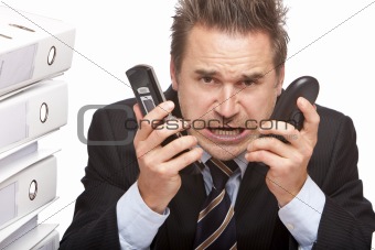 Stressed business man  with two telephones is crying in office 