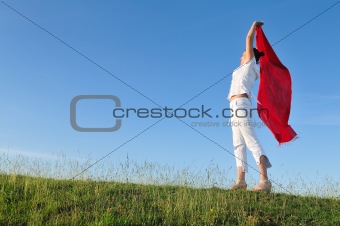 beautiful woman with red scarf on meadow