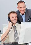 Businessman on phone and working with his colleague
