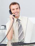 Attractive young businessman talking on phone in the office