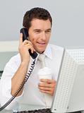 Attractive young businessman talking on phone in the office