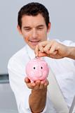 Businessman saving money in a piggybank