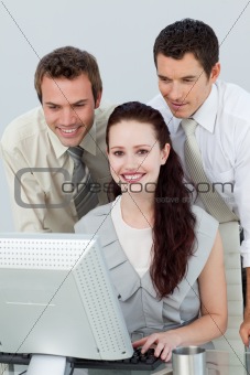 Three young business people using a computer