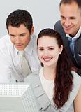 Portrait of a smiling businesswoman and two businessmen using a 