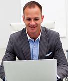 Confident businessman using a laptop in the office