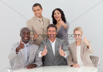 Happy business team celebrating a success with thumbs up