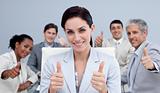 Businesswoman and her team with thumbs up in a meeting