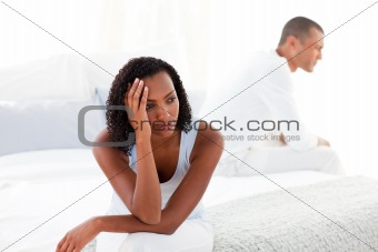 Upset young couple sitting on bed separately