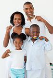 Smiling family brushing their teeth