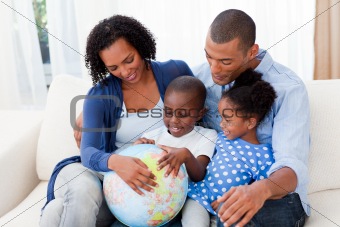 Happy family holding a terrestrial globe
