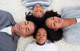 Afro-American young family lying on floor in a circle