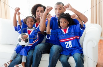 Excited Afro-American family watching a football match