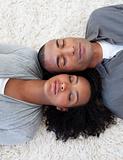 Portrait of Afro-American couple sleeping on the floor at home