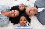 Afro-American young family lying on floor