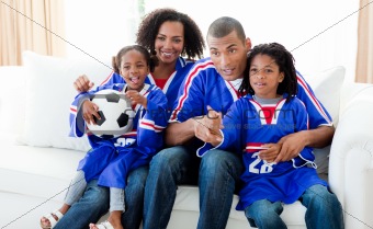 Afro-American family watching a football match at home