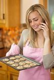 Woman Baking Cookies and Talking on Phone