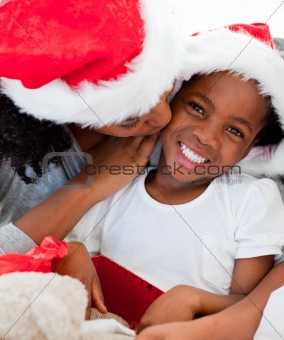 Mother kissing her daughter at Christmas