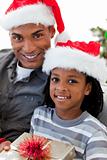 Portrait of an Afro-American father and son holding a Christmas 