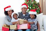Smiling Afro-American family sharing Christmas presents