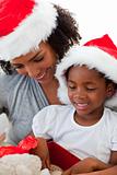 Afro-American mother and daughter opening a Christmas gift