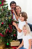 Young family decorating a Christmas tree