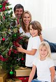 Portrait of a happy family decorating a Christmas tree