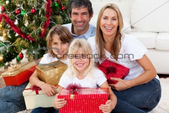 Smiling family holding Christmas presents