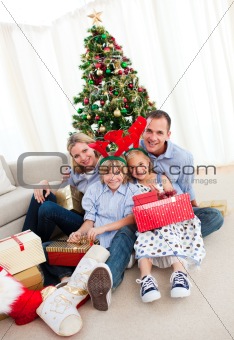 Portrait of a smiling family holding Christmas presents