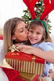 Loving mother kisses daughter at Christmas