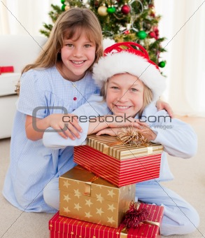 Smiling siblings holding Christmas gifts