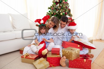 Portrait of a happy family opening Christmas gifts