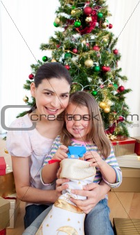 Smiling mother and child playing with Christmas gifts