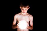 Boy looking into glowing crystal ball