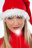 Beautiful young woman in santa's hat holding a red candle