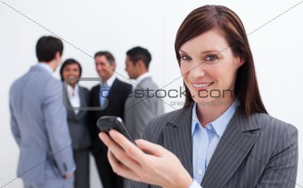 Confident businesswoman writing a text with a mobile phone