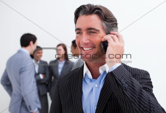 Attractive manager on phone with his team in the background