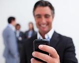 Smiling businessman sending a text with a mobile phone