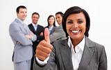 Attractive female executive smiling at the camera with thumb up