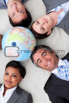 Multi-ethnic business team lying on the floor around a terrestri