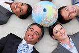 Business people lying on the floor around a terrestrial globe 