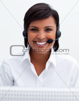 Smiling businesswoman with headset on in a call center
